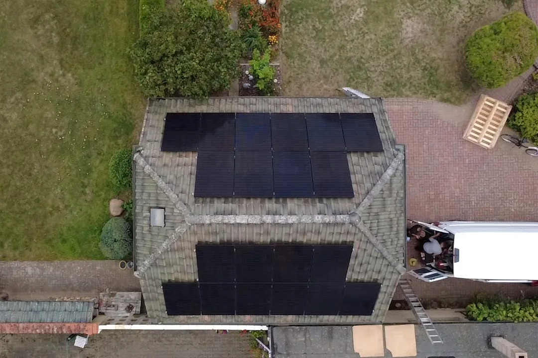 Luftaufnahme eines Einfamilienhauses mit Walmdach, Solarmodule auf zwei Dachflächen